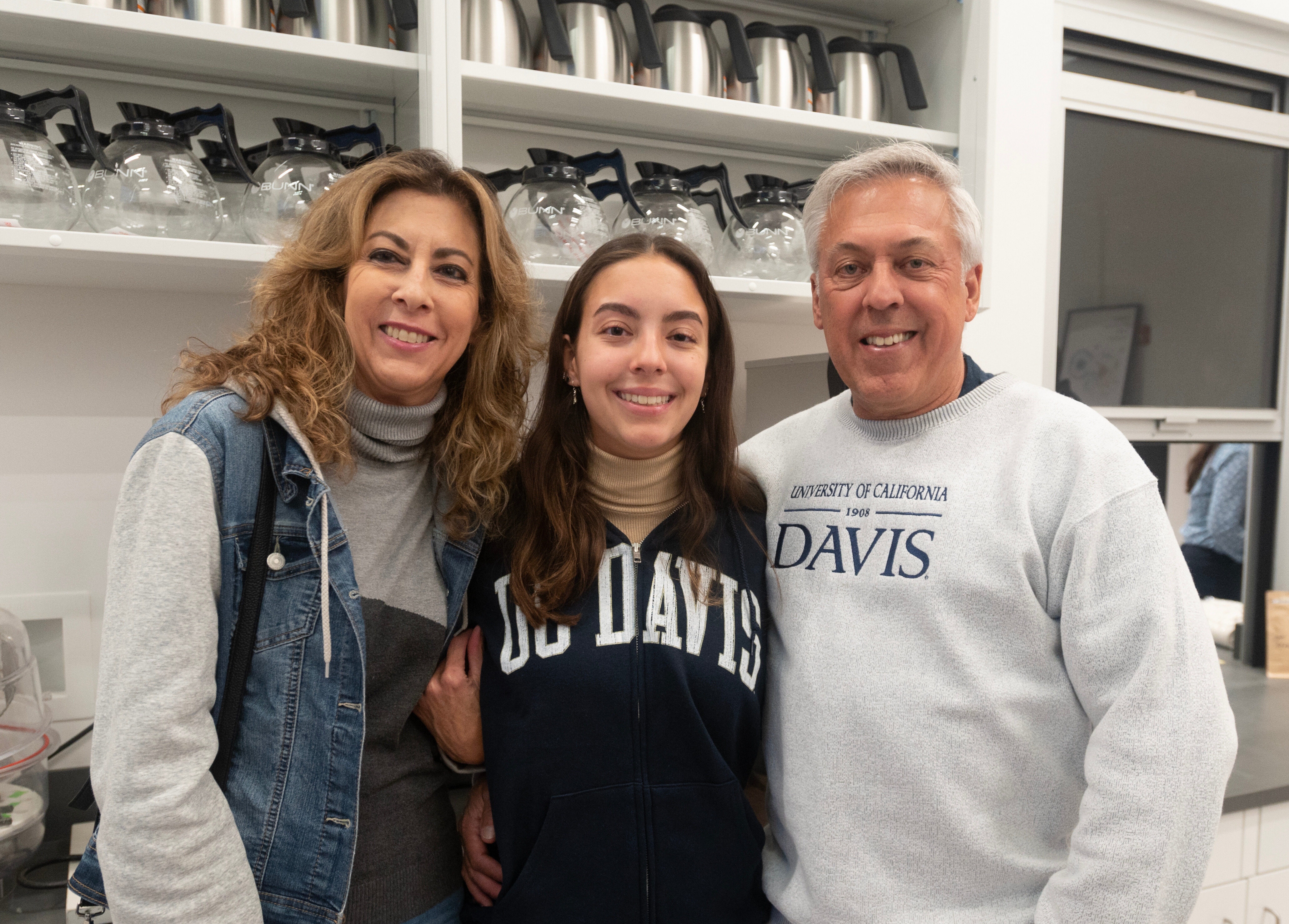 student with parents standing in coffee center kitchen