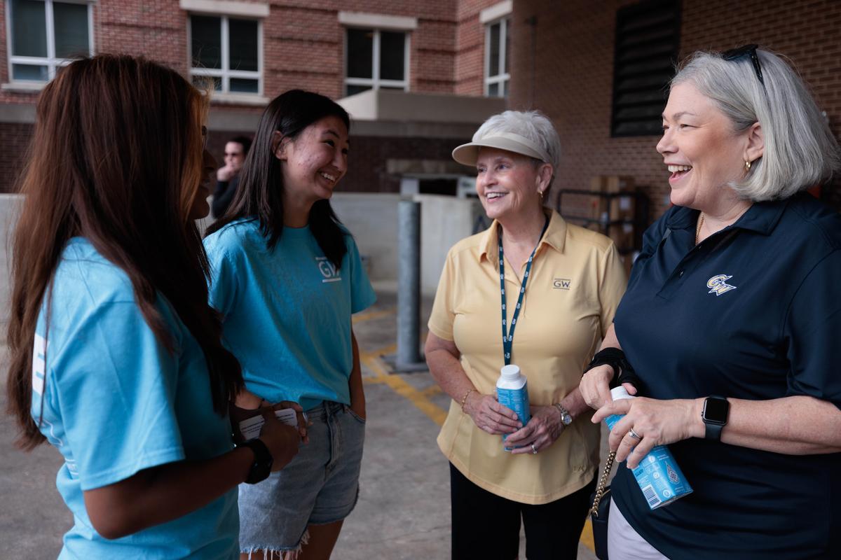 Ellen Granberg (right) welcomes new students moving into GW residence halls.
