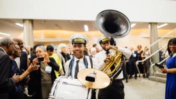 A drummer walking through a crowd of people