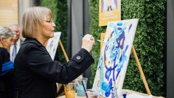 Person painting a canvas on an easel 