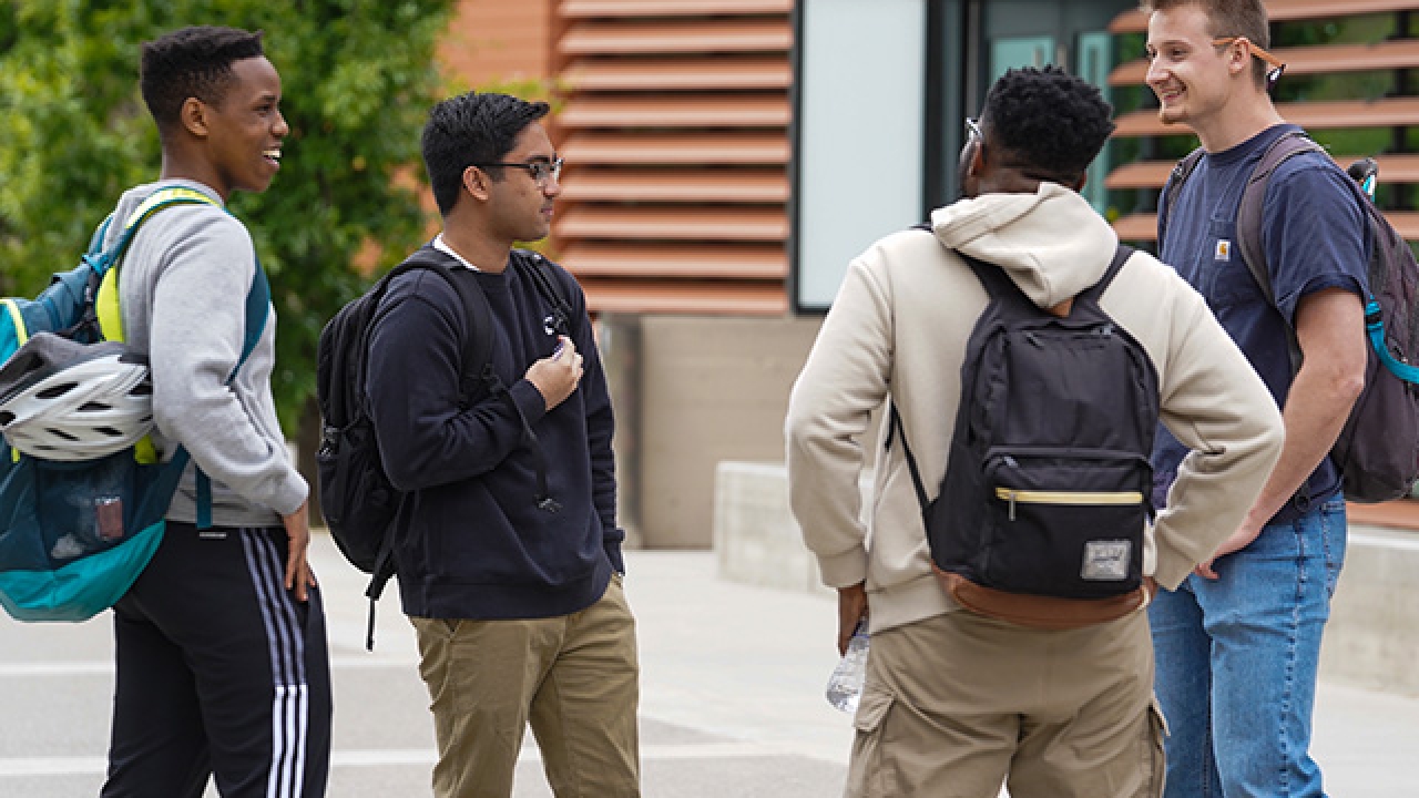 group of four students talking