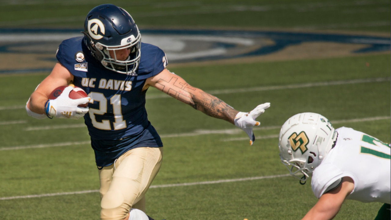 UC Davis football player juking a Cal Poly player