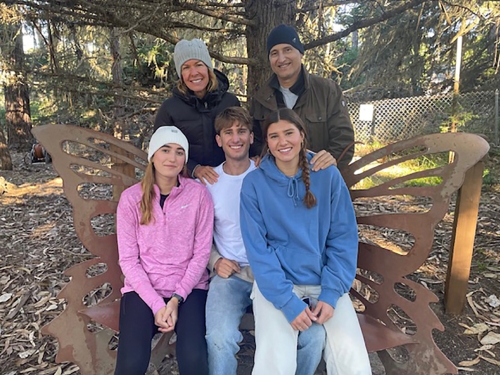 David poses in winter wear with his family outdoors.