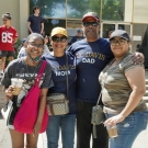 Four people stood in front of a building. The woman second from the left is wearing a UC Davis Mom T-Shirt, and the man to the right of her is wearing a UC Davis Dad T-Shirt.